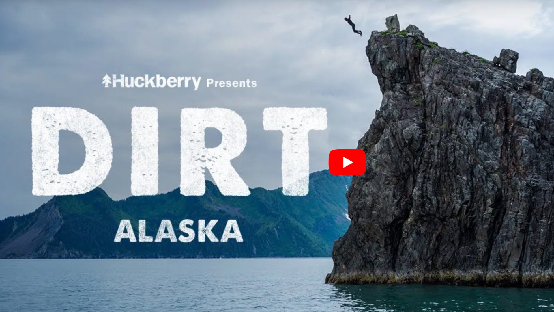 The YouTube thumbnail for DIRT Alaska where a guy is jumping off a giant rock into clear blue water.