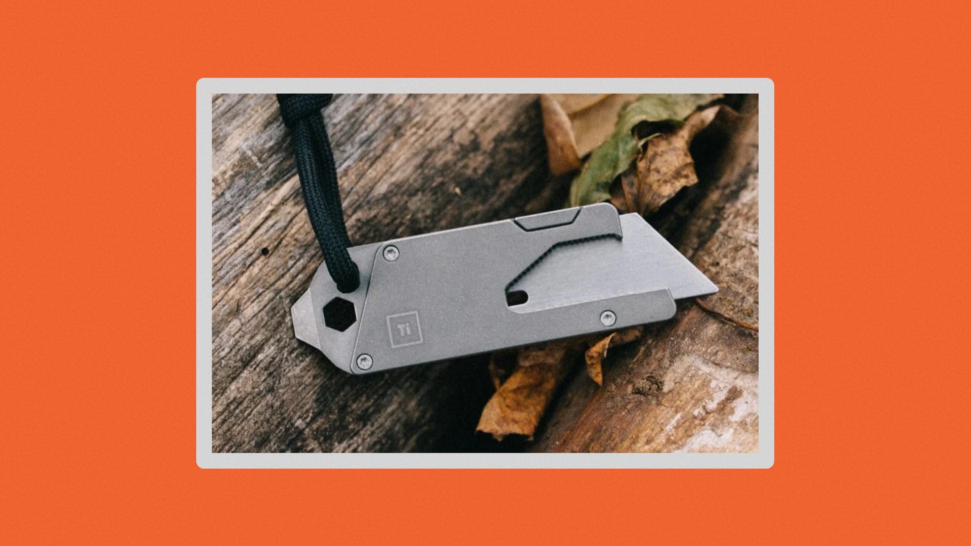 Close-up shot of the TPT with the blade extended on a tree stump with leaves.