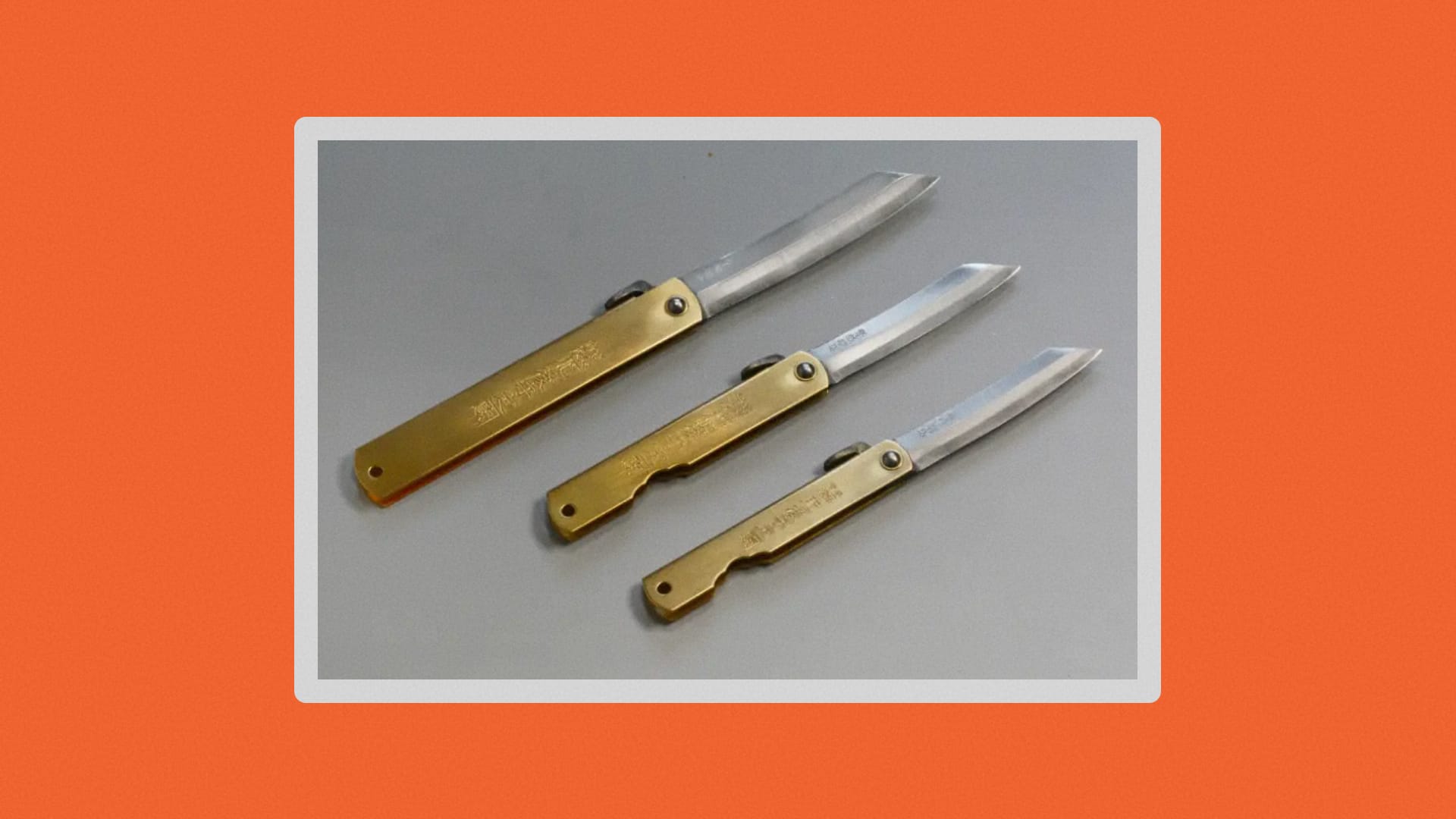 Three brass knives on a gray table.