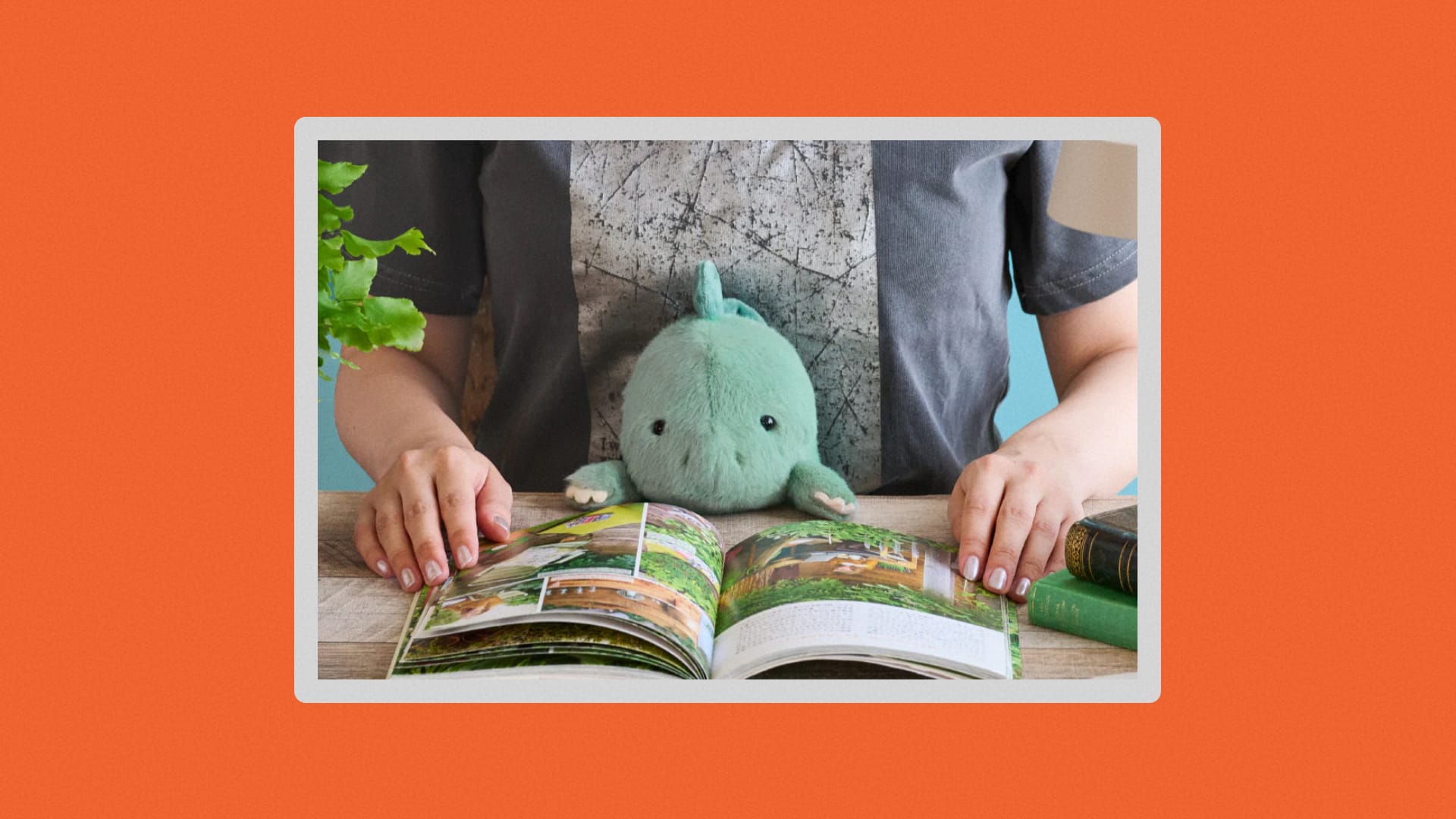 a person reading at a desk pressing the plushie up against the desk.
