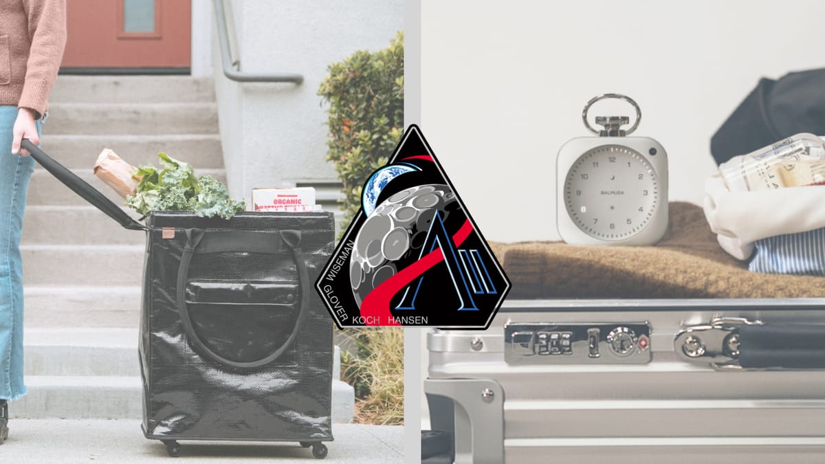Rollable tote filled with groceries on the left, the Artemis II mission patch in the center, and a metal clock on top of luggage on the right.